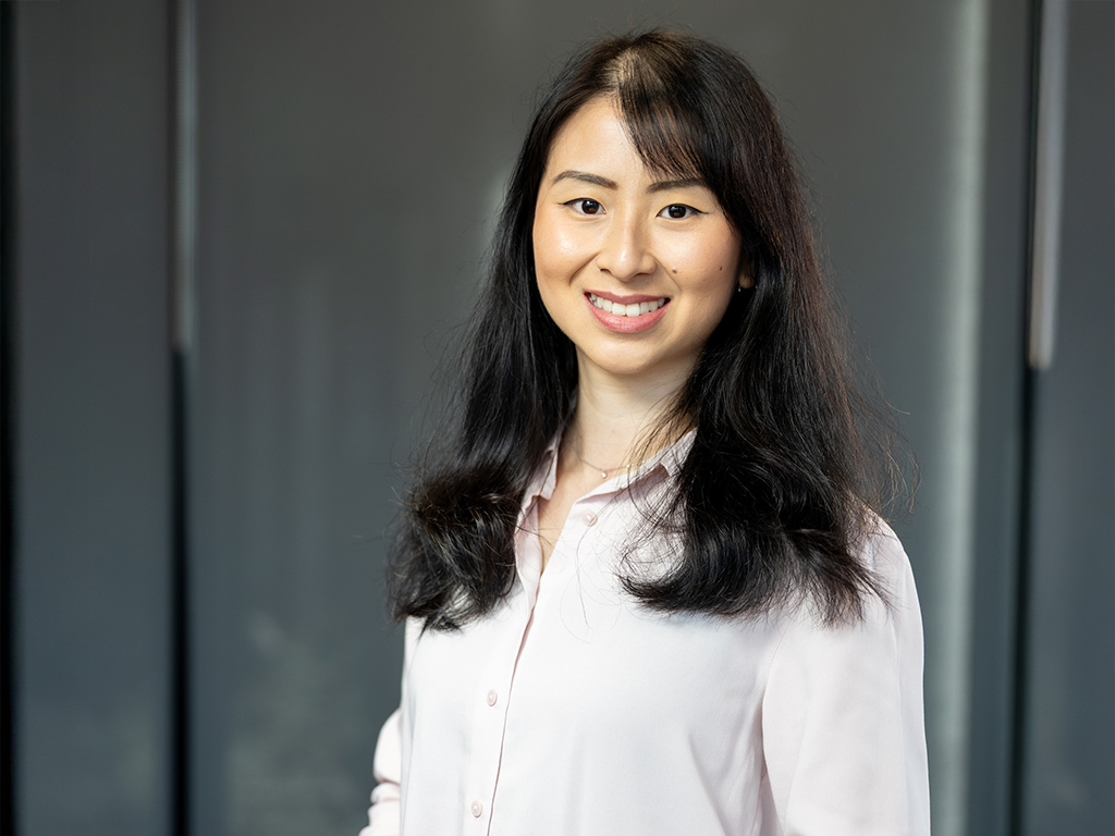 A young woman smiles for the camera in a neat white shirt