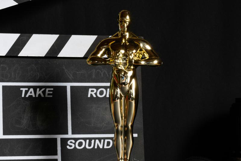 an oscar statue with a movie clapper