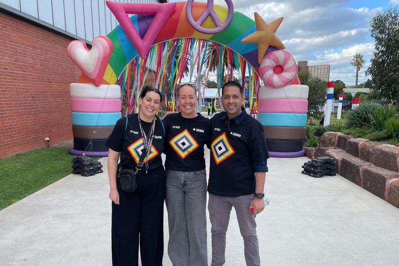 VU staff standing in front of rainbow display at football game