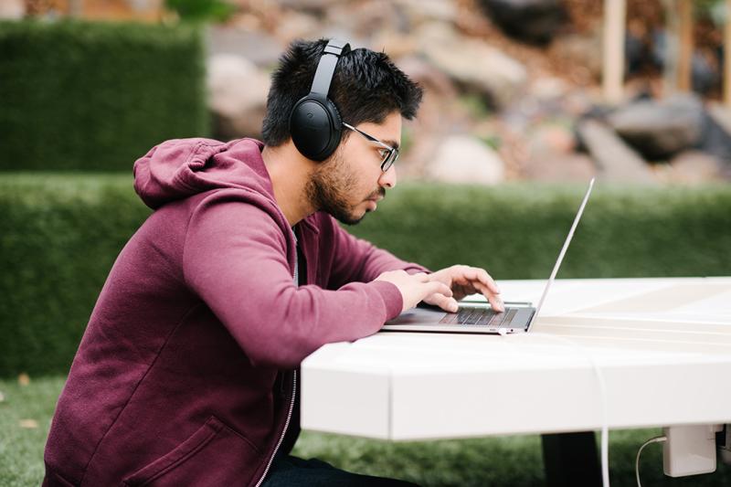 Student using a laptop outdoors on campus 