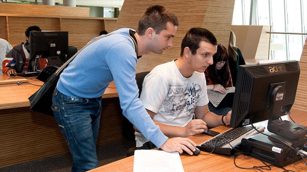 two students engrossed in a computer