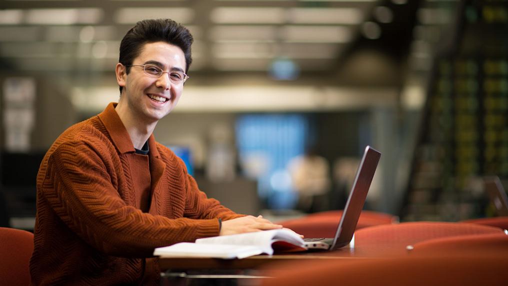 A student sits in front of a laptop at the VU Library.
