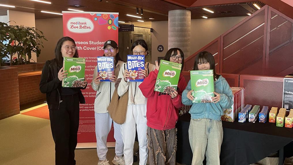 Five students stand holding breakfast cereals in VU's City Tower campus.