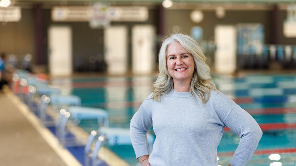 Professor Camilla Brockett stands in front of the swimming pool in Footscray Park Fitness and Aquatic Centre.