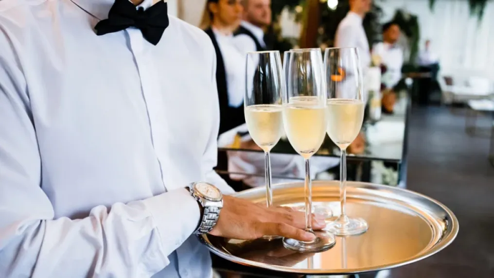 A server carries a tray of champagne